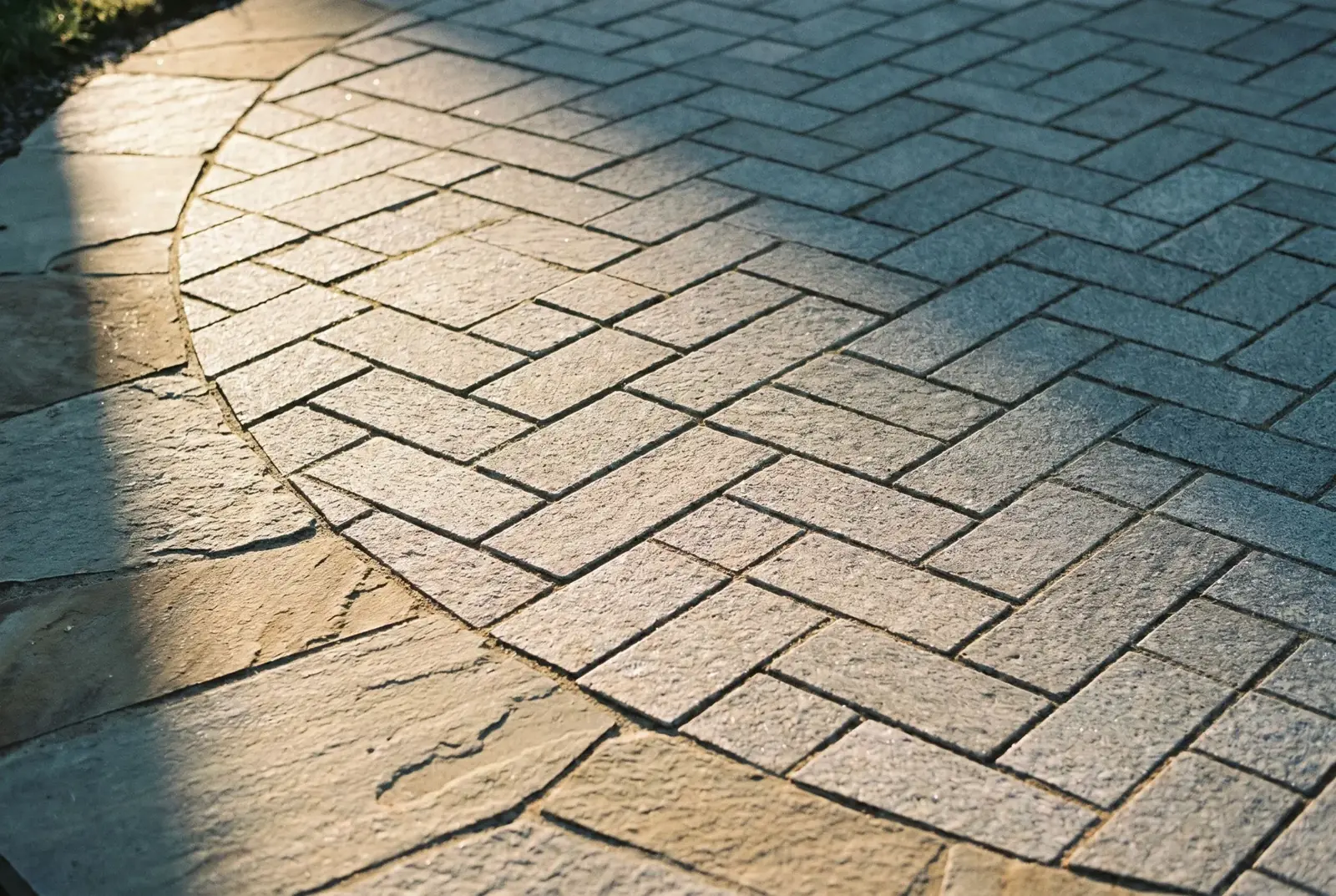 Close-up of herringbone pavers meeting a natural stone border