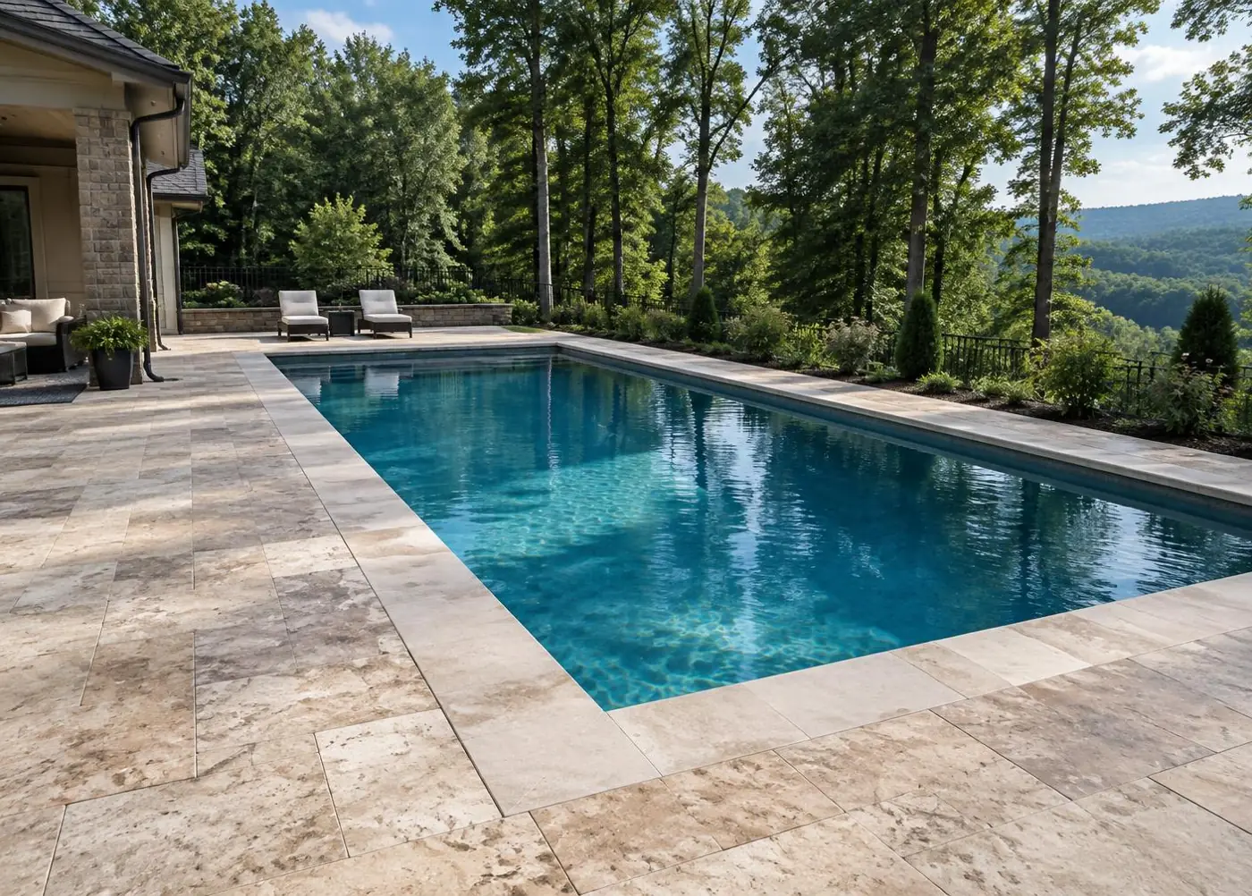 Natural stone paver pool deck surrounding a backyard pool